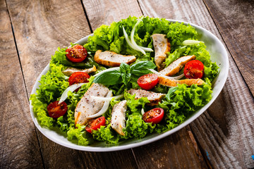 Caesar salad on white plate on wooden table
