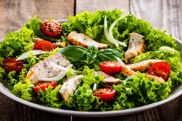 Caesar salad on white plate on wooden table