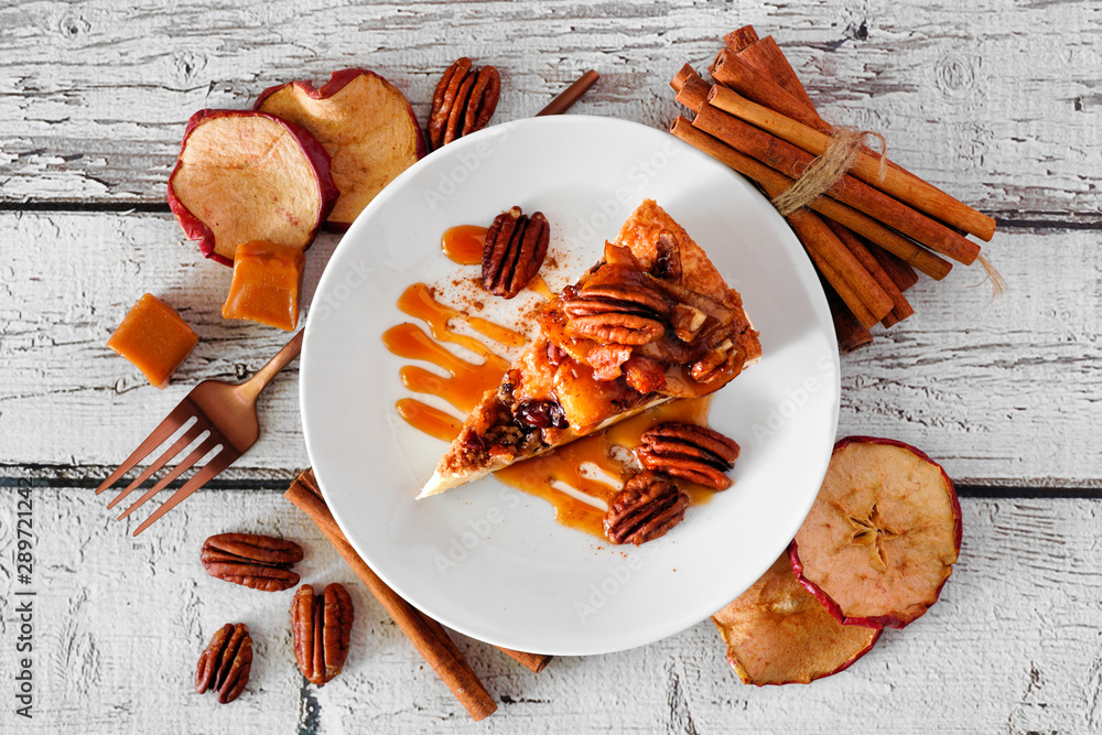 Aufkleber slice of caramel apple pecan cheesecake. top view with frame of ingredients over a white wood backgr