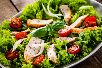 Caesar salad on white plate on wooden table