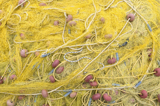 yellow fishing nets on the shore of the port near the sea. fishing, poaching, hobbies. yellow background.