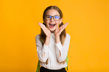 Schoolgirl Shouting In Delight Holding Hands Near Mouth, Studio Shot