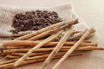 cloves and cinnamon on burlap sacks and wood