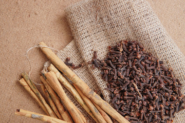 cloves and cinnamon on burlap sacks and wood
