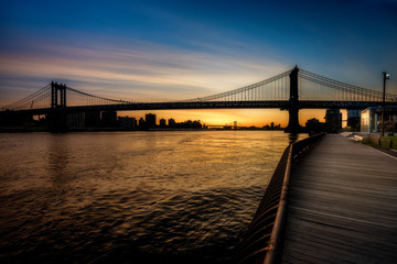 Fototapeta na wymiar Boardwalk leads into the sunrise and fancy bridge New York