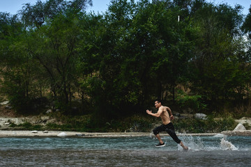 Asian athlete on a morning run on the river, Kazakh jogger in nature close-up