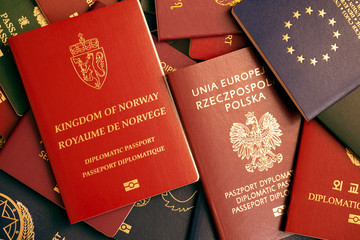 Kingdom of Norway biometric diplomatic red passport on a colorful background of passports of...