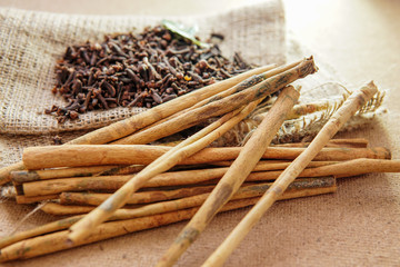 cloves and cinnamon on burlap sacks and wood