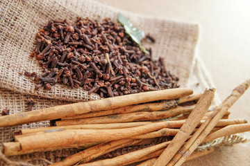 cloves and cinnamon on burlap sacks and wood