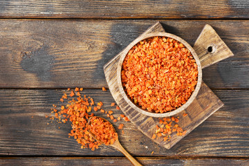 Dried carrots in a wooden bowl on a wooden table. Soup seasoning. Top view