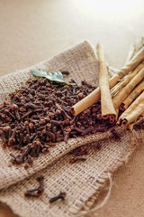 cloves and cinnamon on burlap sacks and wood