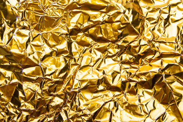 Gold crumpled foil paper texture background.