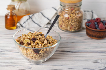 Homemade granola with raisins, nuts and berries in a glass bowl