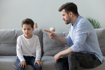 Angry father scolding sad kid son for bad behavior