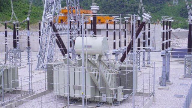 High voltage transformer at the hydroelectric dam.Large power generation systems connected to the city.Is an important technology of electricity.Clean electrical energy.	