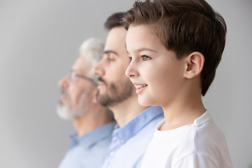 Child boy grandson stand in row with father and grandfather