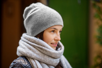 Beautiful woman in a gray knitted hat and scarf. Concept lifestyle, autumn, urban.