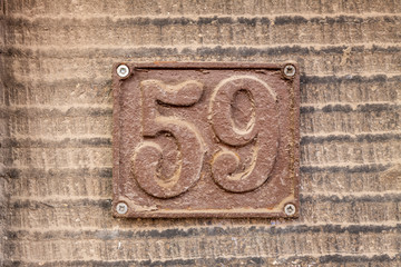 Number 59, fifty nine, street number sign on the wall