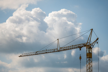 A crane  for lifting heavy loads with blue sky and clouds