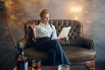 Woman reading newspapar with whiskey and cigar - obrazy, fototapety, plakaty