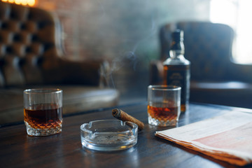 Whiskey and cigar on wooden table in retro office