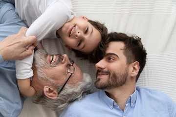 Affectionate multi three generation men family top view closeup portrait