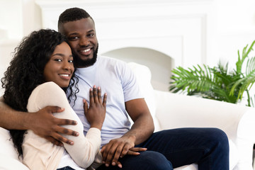 Married couple sitting at home posing to camera
