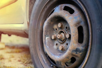 replacing a wheel in a car, loosening nuts with a hand wrench.