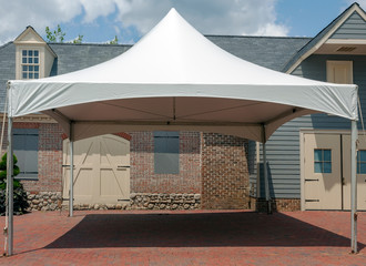 White event tent canopy erected on brick patio. - obrazy, fototapety, plakaty