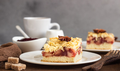 Apple, red berry jam and spices crumble topping cake and cup of coffee on wooden tray.