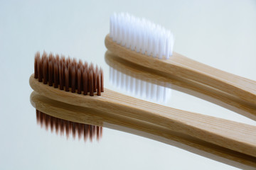 Close-up wooden toothbrushes on mirror. Mirror reflection. Plastic free, ecological, zero waste,...