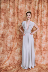 Nice woman with elegant Hairstyle. Brunette Fashion Model Woman wearing Summer Prom long maxi transformer Dress