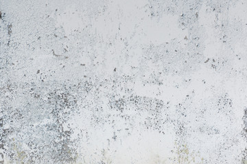 Light wall with cracked peeling paint. Backgrounds and textures