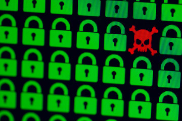 Skull and bone as a symbol of hacking programs or personal information and data. Cyber crime. Green pixel castles and a red skull with bones on a black background, close-up