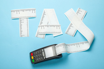 Tax from paper bill and POS terminal for payment on blue background