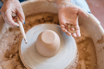 Wet pot on pottery wheel in workshop