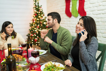 Smiling Woman Giving Merry Christmas Wishes On Mobile Phone At Home