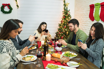 Group Of Friends Ignoring Each Other And Looking At Cellphones In Party