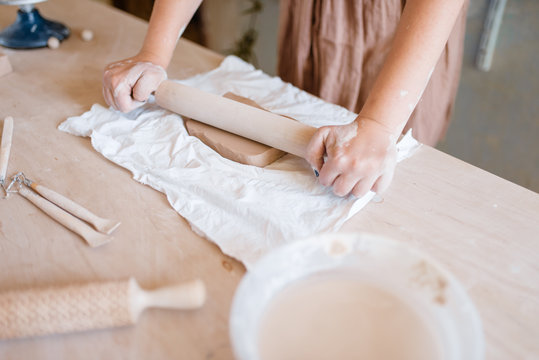 Female potter roll out foarm with a rolling pin