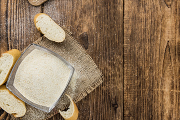 Some fresh Bread Crumbs on wooden background (selective focus; close-up shot)