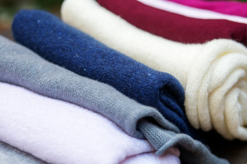 Fototapeta na wymiar Stack of knitted downy scarfs for background. Woolen shawls.