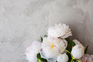 Stylish minimalist design with white peony on a gray background texture of cement.