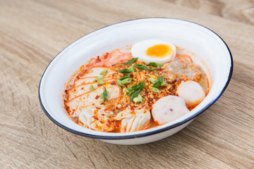 Thai Food noodle Tom Yum Bo Ran spicy in galvanized iron bowl on wood table traditional local thai street food