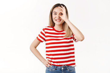 Okay deal. Optimistic cute blond asian female student showing zero ok gesture hold circle eye look through happily smiling toothy touch waist assured plan goes well approve excellent work done