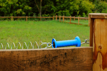 Electric shepherd, close-up. Stable, fencing, fence, cropped shot. Wooden fence in the stable.