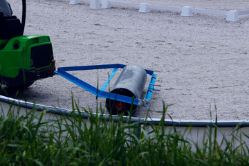 The machine aligns the sand in the exit arena. Preparing the arena for dressage. Dressage, Equestrian, Preparation concept. 