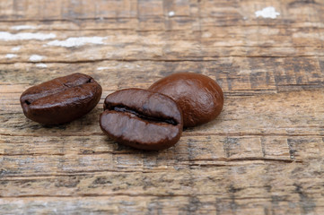Grains of coffee on an old wooden surface.