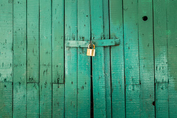 old wooden door painted in green with a lock