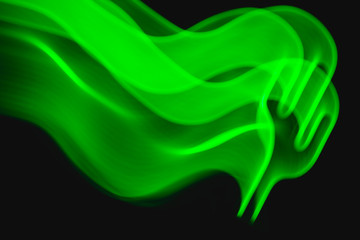 Neon green cactus LED lamp in motion as blurred abstract background on black.