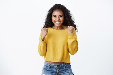 Yes deal mine. Successful african-american cute woman in yellow sweater, smiling happily,...